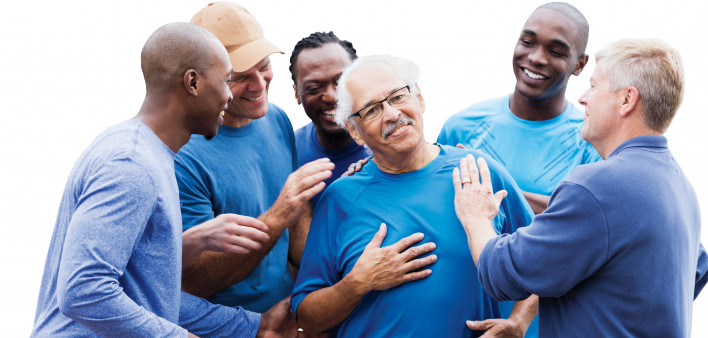 group of men supporting one man smiling