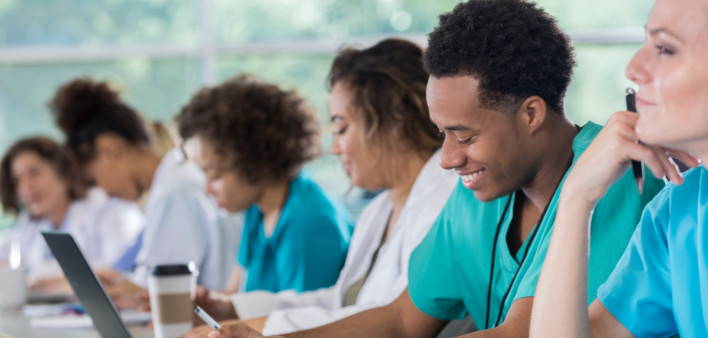 Diverse pre-med students take notes during class